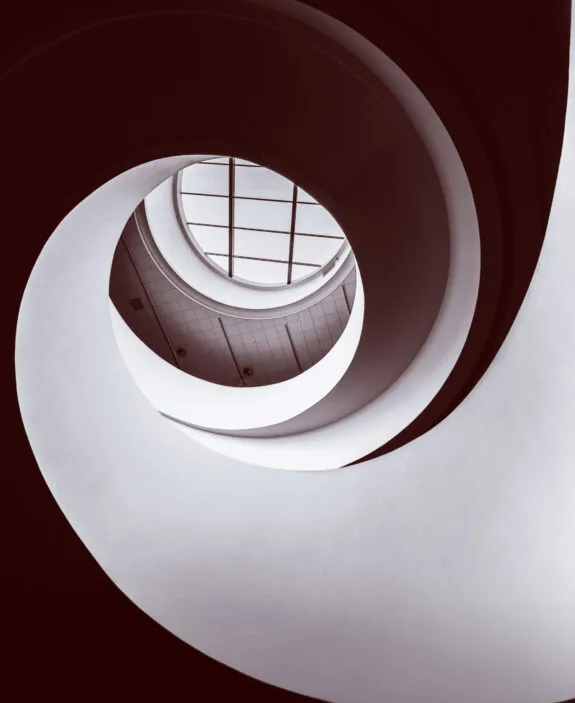 Spiral staircase with skylight viewed from below.